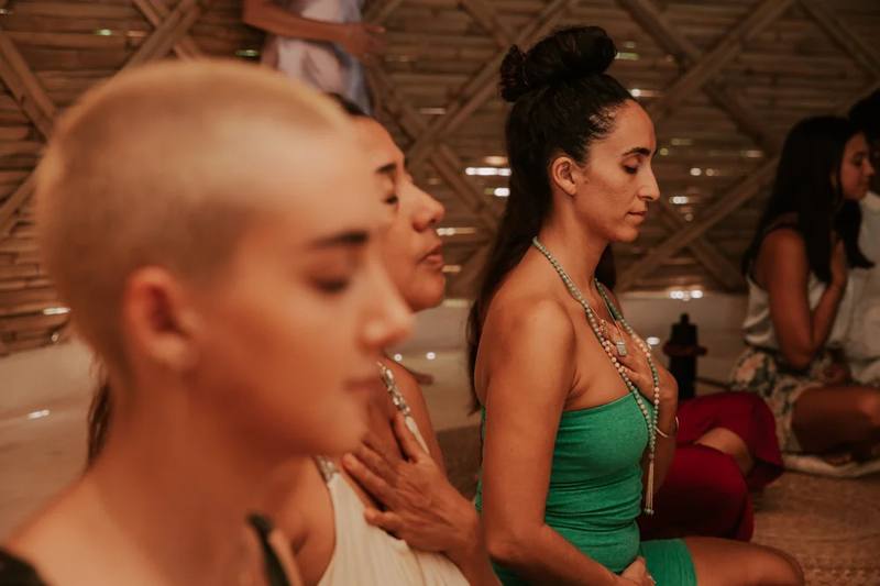 Guests in seated meditation beneath a woven bamboo dome