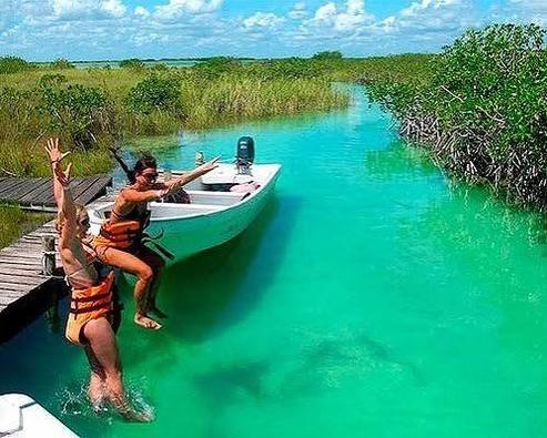 Guests jumping from a dock into the turquoise canals of Sian Ka'an