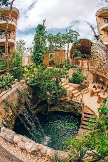Cenote and ceremony spaces surrounded by jungle and woven domes