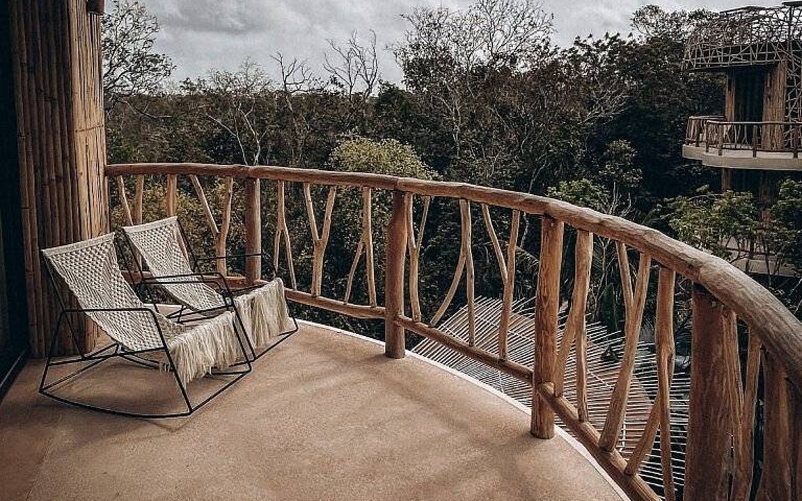 Two chairs on a private balcony overlooking the jungle